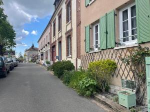 una calle en una ciudad con casas con persianas verdes en Sous la Glycine, en Giverny