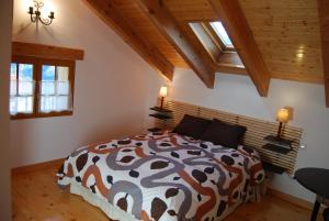 1 dormitorio con 1 cama con edredón marrón y blanco en Casa Rural Natura Sobron en Sobrón