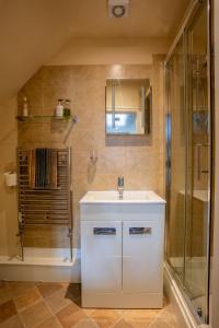 a bathroom with a white sink and a shower at Harmony House Boutique B&B in Stillingfleet