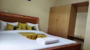 Un dormitorio con una cama blanca con toallas. en Lacasa accommodation en Naivasha
