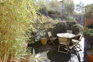 a patio with a table and chairs in a garden at The Cloudesley Guesthouse in Hastings