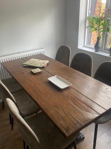 a wooden table with chairs and a laptop on it at The White Hart Apartment Valley View in Alton