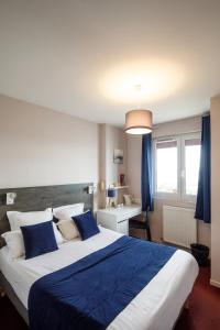 a bedroom with a large bed with blue sheets at Saint Aubin Logis Hôtel & Restaurant in Saint-Aubin-sur-Mer