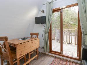 a room with a desk and a sliding glass door at Pod No 19 in Keswick
