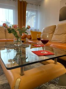 een woonkamer met twee glazen wijn op een glazen tafel bij Apartamenty Grodowa 2 in Gliwice