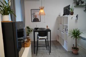 a small table with a chair in a room with plants at Comfortable Apartment & Studio in Village Centre in Komen