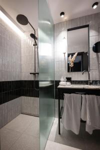 Gentle Hide Designhotel في سالزبورغ: حمام مع دش ومغسلة ومرآة