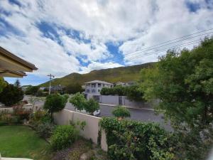 - une vue sur une cour avec une maison et une montagne dans l'établissement Steenbok House self catering Apartment, à Hermanus