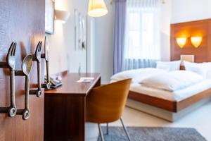 ein Hotelzimmer mit einem Schreibtisch und einem Bett in der Unterkunft Romantikhotel Rebstock art & design in Kehl am Rhein