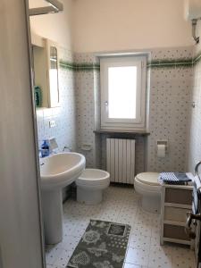 baño con lavabo y aseo y ventana en Il lupo e la volpe - parcheggio gratis, en Centobuchi