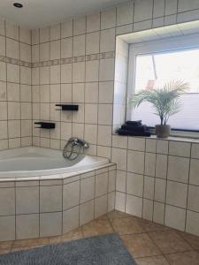 baño con bañera con ventana y planta en Gästehaus Theo, en Gotha