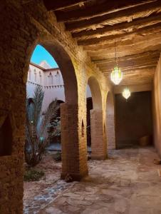 an old building with arches in a courtyard at Auberge Famille Benmoro in Skoura