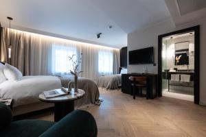 Großes Hotelzimmer mit einem Bett und einem Tisch in der Unterkunft Gentle Hide Designhotel in Salzburg