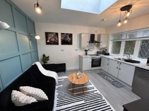 een woonkamer met een bank en een tafel bij Vibrant Bungalow 2 Bedroom Flat with secure private parking in Birmingham