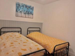 מיטה או מיטות בחדר ב-Vibrant Bungalow 2 Bedroom Flat with secure private parking