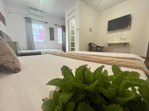a bedroom with two beds and a tv on the wall at Nhật Vân 2 in Ho Chi Minh City