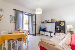 sala de estar con mesa y sofá en Villetta Bel Mare With Garden Near Sea - Happy Rentals, en Melendugno