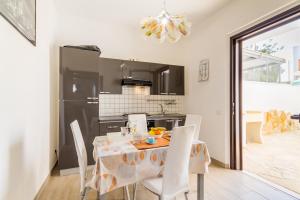 cocina y comedor con mesa y sillas en Villetta Bel Mare With Garden Near Sea - Happy Rentals, en Melendugno