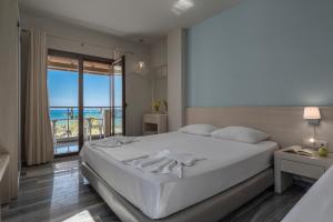 a bedroom with a bed with a view of the ocean at Alkioni By The Sea in Siviri