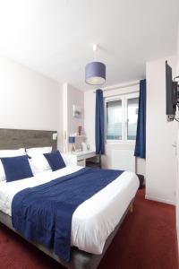 a bedroom with a large bed with blue and white sheets at Saint Aubin Logis Hôtel & Restaurant in Saint-Aubin-sur-Mer