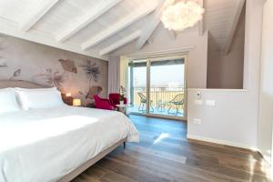 a bedroom with a large bed and a balcony at Re Ottone Rooms in Lazise