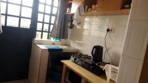 a small kitchen with a stove and a sink at Lacasa accommodation in Naivasha