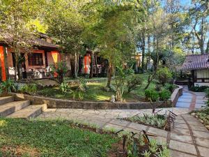a garden with stairs and trees and a house at Estalagem Wiesbaden in Monte Verde