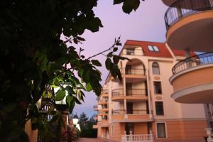 a building with two balconies next to a tree at Apart Hotel Apolonia Palace in Sinemorets