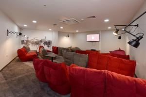 a living room with red couches and a screen at For Students Only Cosy Ensuite Rooms With Private Bathrooms at Dobbie's Point in Glasgow in Glasgow