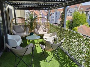 een patio met stoelen en tafels op een balkon bij Chambre deluxe au 2ème étage, chambre double au 4ème étage PAS UN HÔTEL in Brussel