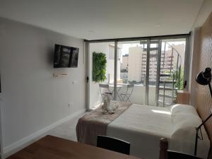 een slaapkamer met een bed en een groot raam bij Koka View in Playa del Inglés