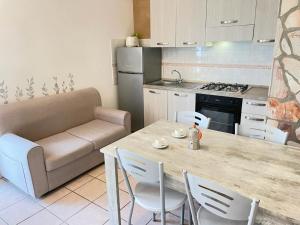 cocina con mesa, sillas y sofá en Appartamento Lavigna, en Marina di Camerota