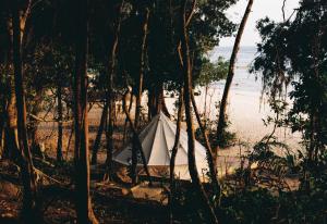 una tenda sulla spiaggia in mezzo agli alberi di KAMAKU Bungalows a Koh Rong Sanloem