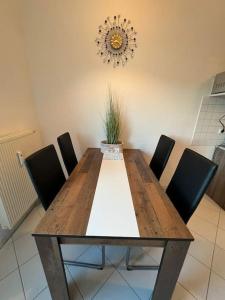 uma mesa de jantar com cadeiras e um vaso de plantas em Fewo 3 em Gotha