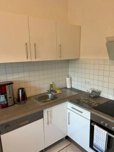 a kitchen with white cabinets and a sink at Fewo 3 in Gotha