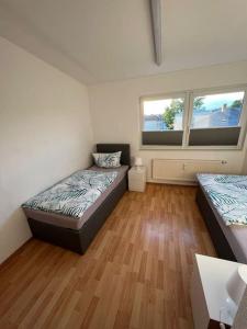 um quarto com 2 camas e piso em madeira em Fewo 3 em Gotha