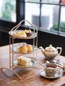 a three tiered tray of pastries and tea cups on a table at Milestone SaiGon in Ho Chi Minh City