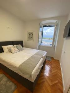 Un dormitorio con una cama grande y una ventana en Beach House Tisno with Sea View, en Tisno