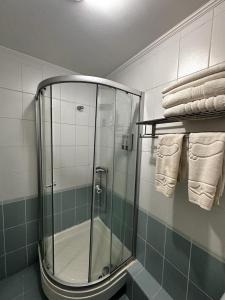 a glass shower in a bathroom with towels at Санаторий Казахстан in Gornyy Gigant