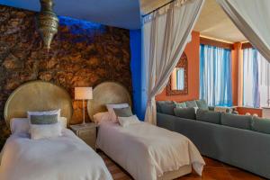 salon z dwoma łóżkami i kanapą w obiekcie Mediterráneo Outdoor Pool w Maladze