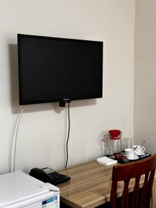 a flat screen tv on a wall above a desk at Санаторий Казахстан in Gornyy Gigant