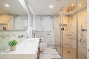 a bathroom with a shower and a sink and a toilet at Ocean Vista - Premium CityCenter in Ponta Delgada +93 photos