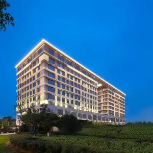 a large white building with a lot of windows at Bosai Hotel Shanghai Hongqiao Railway Station National Convention and Exhibition Center in Shanghai