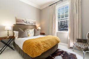 فندق Long Street البوتيكي في كيب تاون: غرفة نوم عليها سرير مع بطانية صفراء