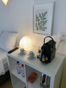 une table blanche avec une lampe et des tasses dessus dans l'établissement Mango Spirit Suites, à Neuchâtel