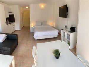 Cette chambre comprend un lit, une table et un canapé. dans l'établissement Mango Spirit Suites, à Neuchâtel