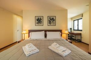 a bedroom with a large bed with two towels on it at Ocean Vista - Premium CityCenter in Ponta Delgada