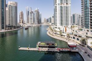 ein Boot auf einem Fluss in einer Stadt mit hohen Gebäuden in der Unterkunft Frank Porter - Marina Views Tower in Dubai