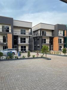 un aparcamiento frente a un complejo de apartamentos en Mayvad Homes, en Kampala