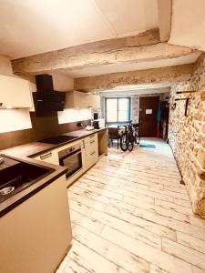 eine Küche mit weißen Geräten und einer Steinmauer in der Unterkunft Kamer met kitchenette in Bédoin